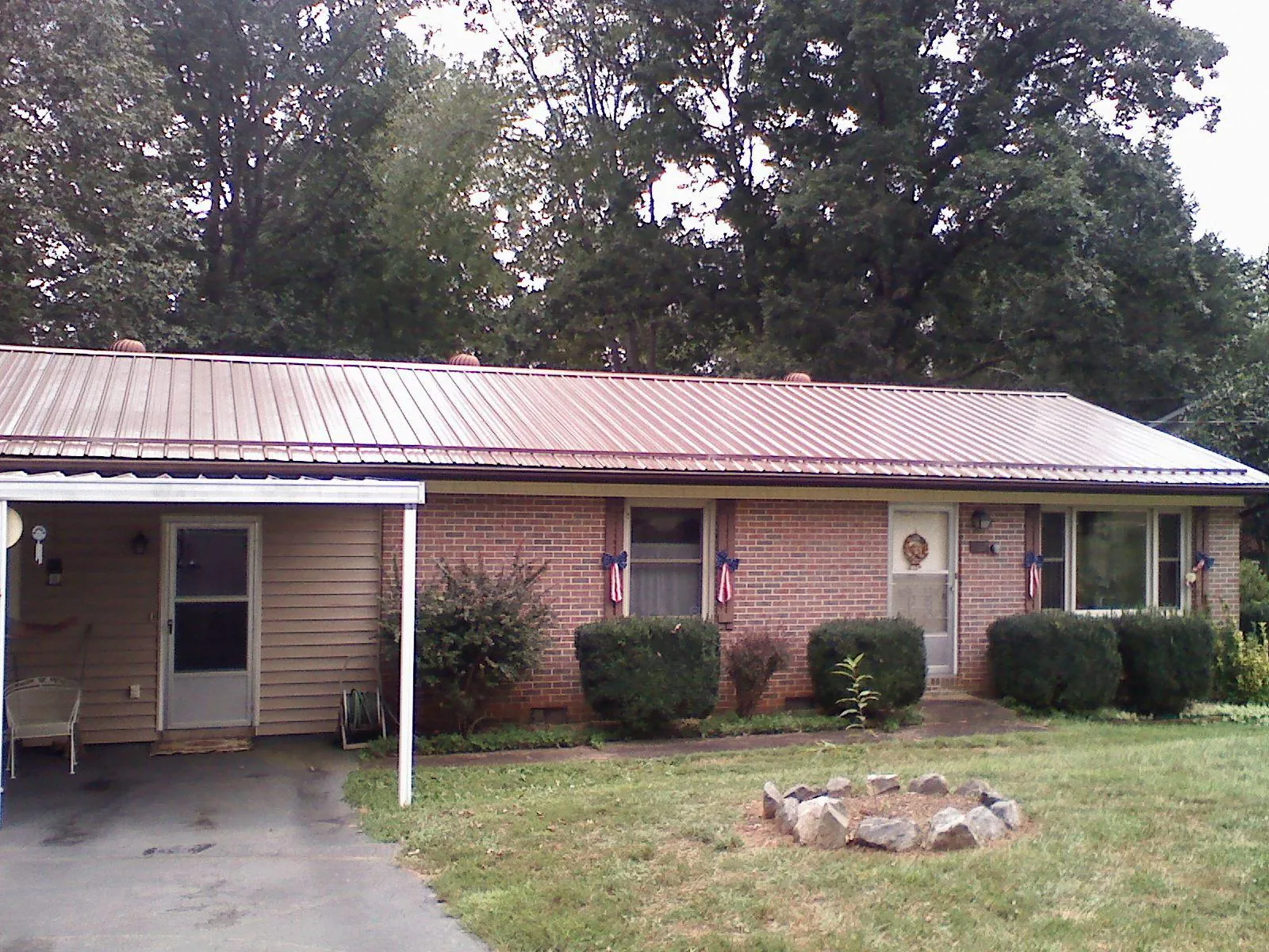 Bronze metal roof and carport on a brick ranch home — Roof Repair work by our crew in Luxemburg